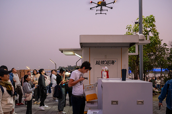 在深圳,外國(guó)游客體驗(yàn)無人機(jī)外賣送餐。