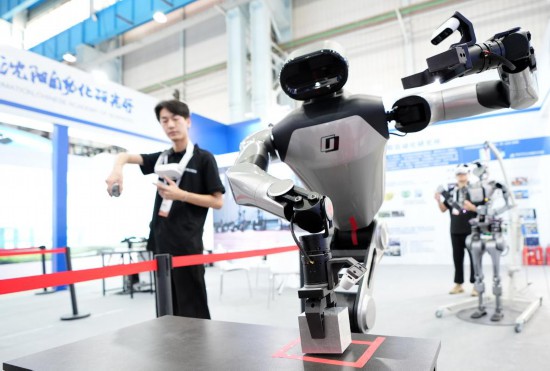 9月5日，在沈陽的2025全球工業(yè)互聯(lián)網(wǎng)大會的展覽區(qū)現(xiàn)場，中國科學(xué)院沈陽自動化研究所的機器人工程師在調(diào)試具身智能操作系統(tǒng)。新華社記者 李鋼 攝